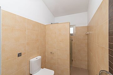 A bathroom with a toilet and a shower stall