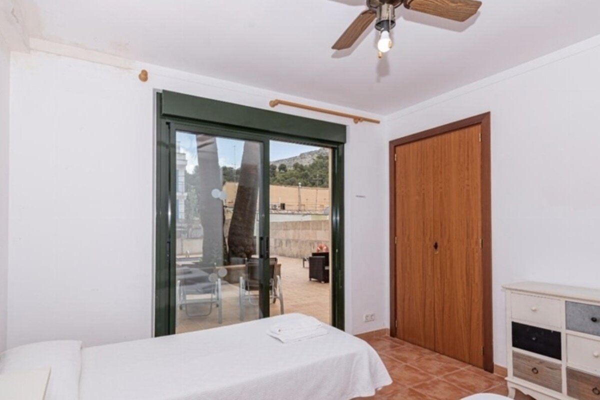 A bedroom with two beds and a ceiling fan