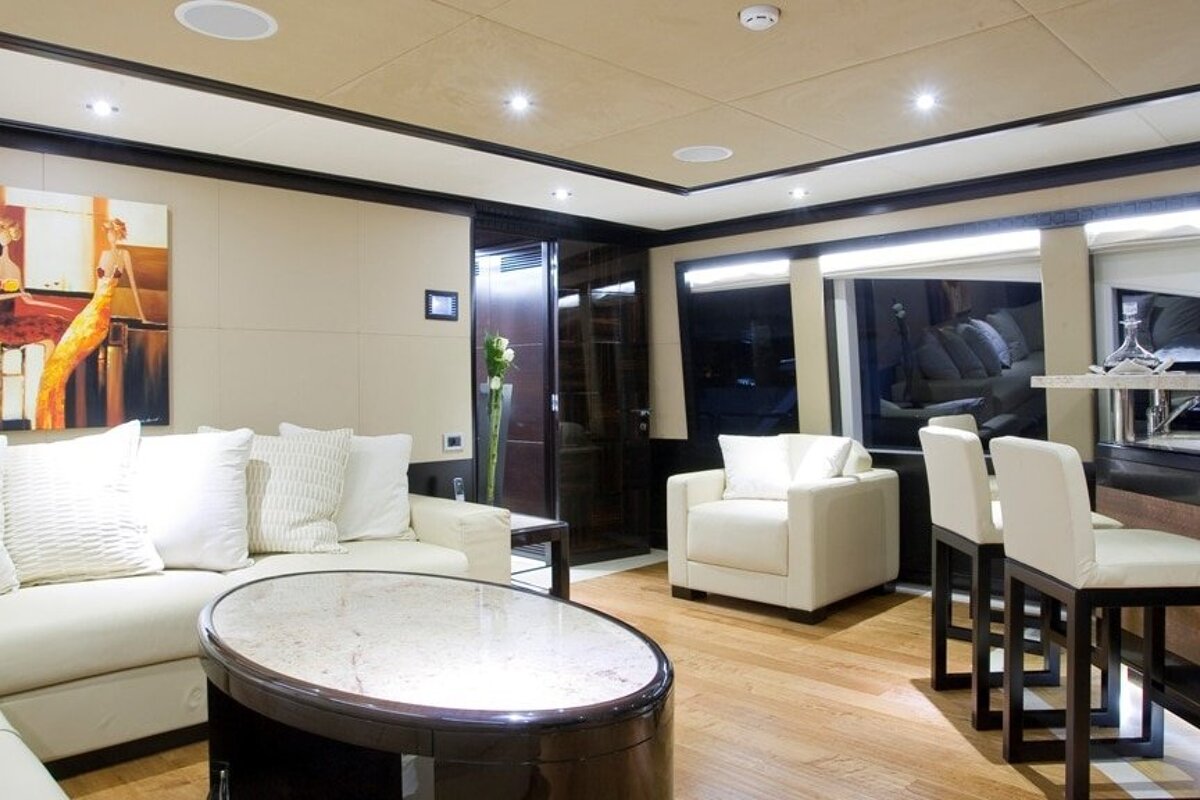 A living room with white furniture and a painting on the wall