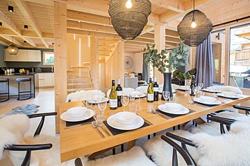A dining room table with plates and wine bottles on it