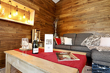 A living room with a couch and a table with a bottle of champagne on it