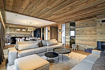 A living room with a couch and a table with a bag that says ' valentino ' on it