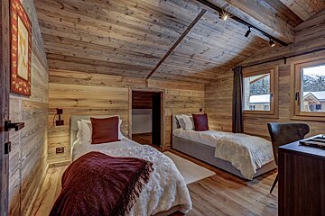 A bedroom with two twin beds and a desk