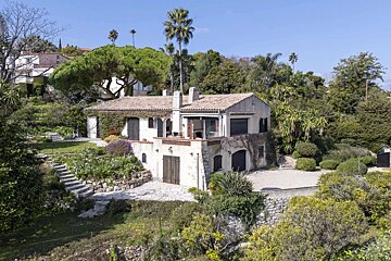 An aerial view of a house surrounded by trees and bushes