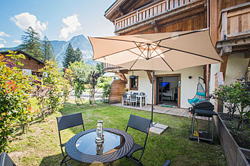 A patio with a table and chairs under an umbrella