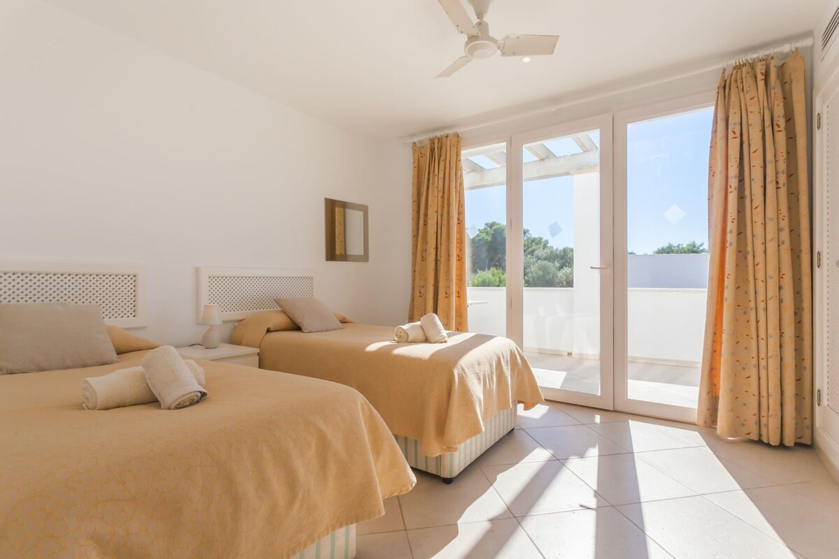 A bedroom with two beds and a ceiling fan
