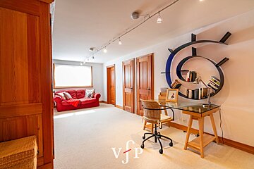 A room with a couch and a desk with vfp written on the bottom