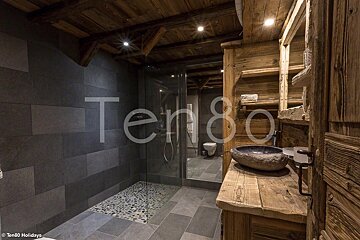 A bathroom with a stone sink and a sign that says ten80