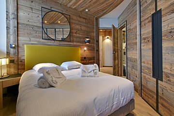 A bedroom with a bed and a mirror on the wall