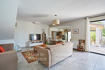 A living room with a couch and a television made in provence by janssens immobilier
