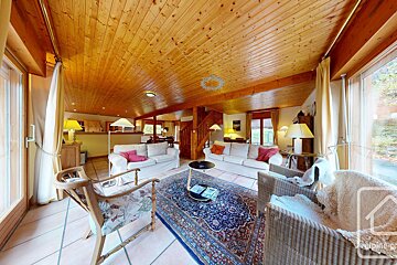 A living room with a wooden ceiling and a rug