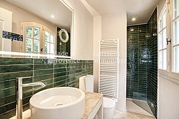A bathroom with green tiles and a sign that says made in provence