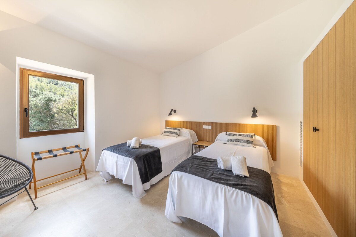 A bedroom with two twin beds and a window