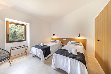 A bedroom with two twin beds and a window