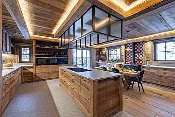 A kitchen with wooden cabinets and a large island in the middle