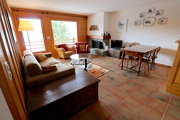 A living room with a couch a chair a table and a fireplace