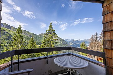 A balcony with a view of mountains and trees