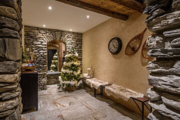 A stone wall with a clock and snowshoes on it