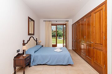 A bedroom with a blue bed and wooden cabinets