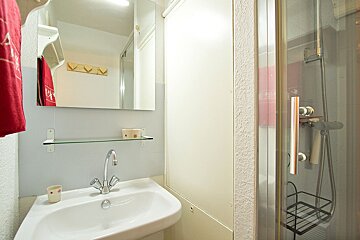A bathroom with a sink a mirror and a shower