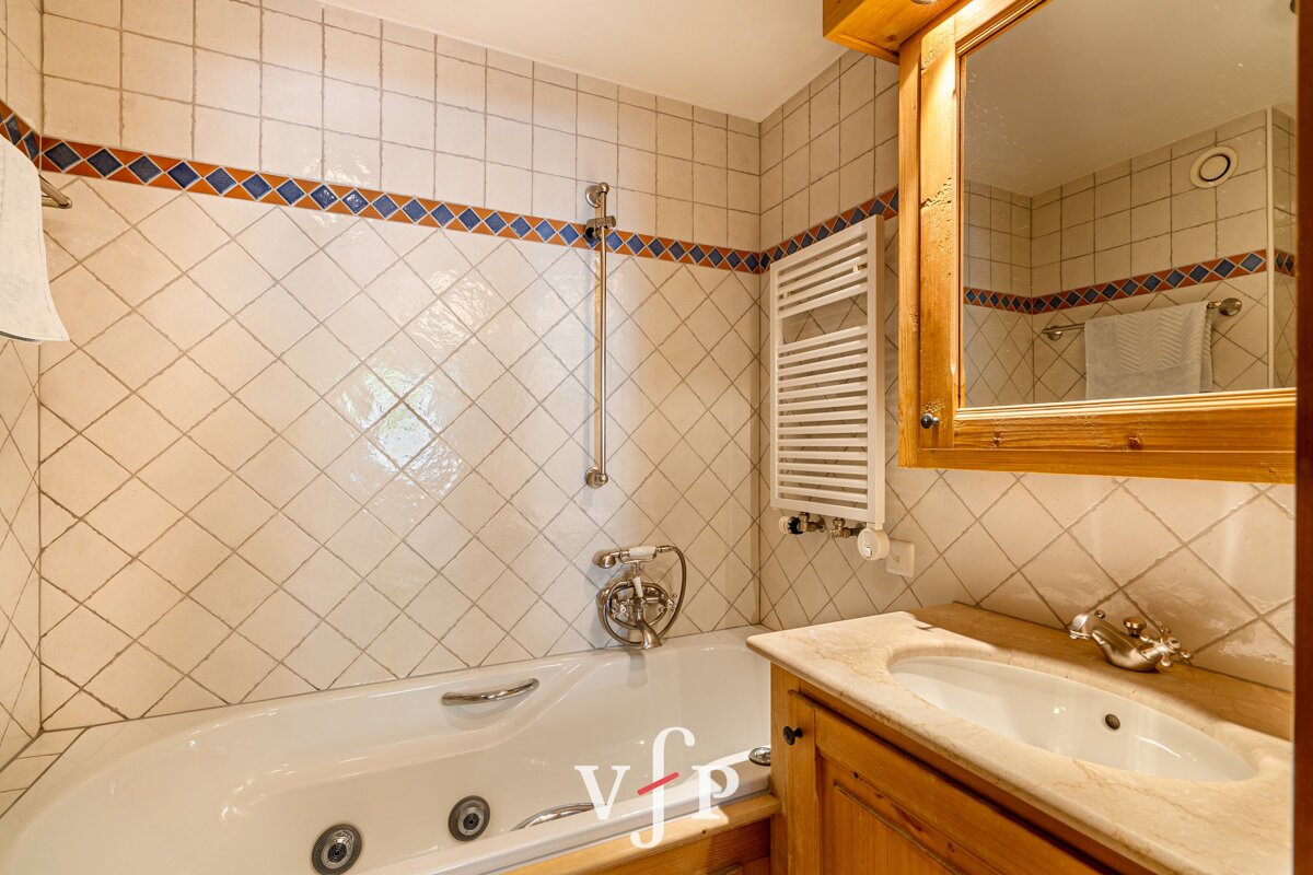 A bathroom with a bathtub and a sink with the letter v on the bottom