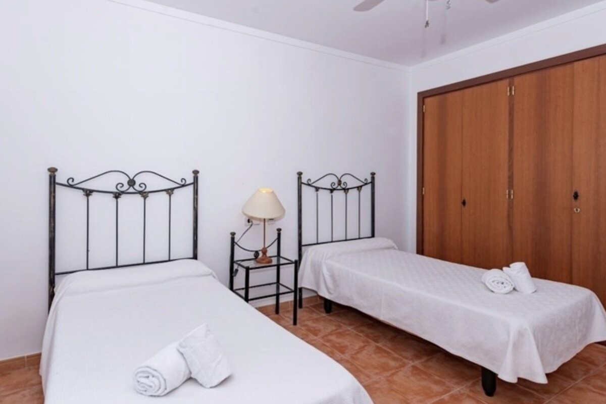 A bedroom with two beds and a lamp