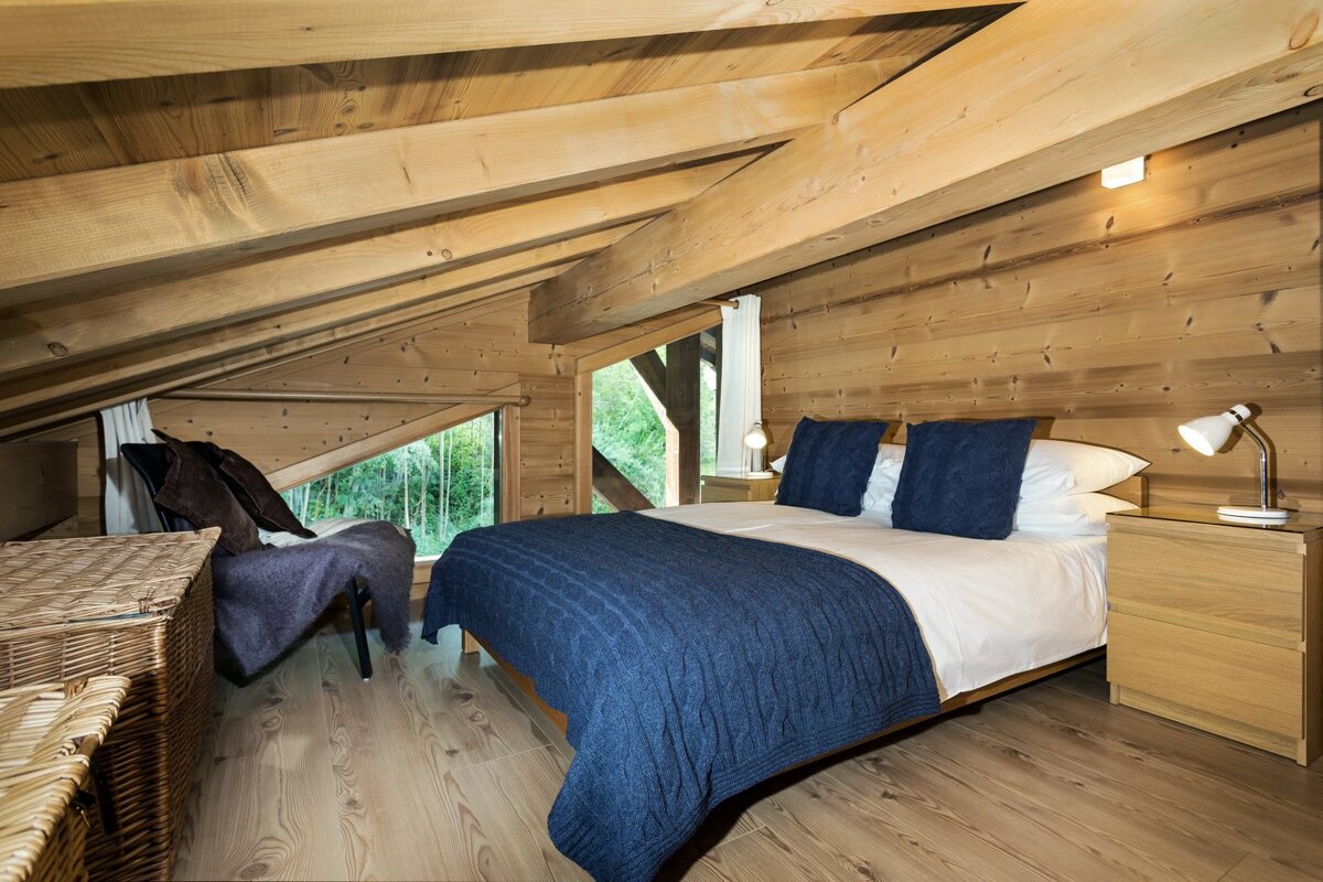 A bedroom with a bed and two nightstands in the attic