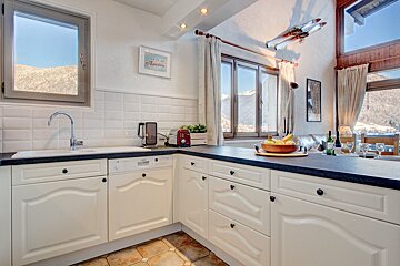 A kitchen with white cabinets and black counter tops