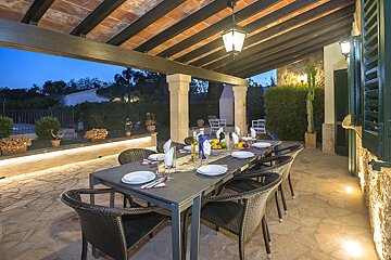 A patio with a table and chairs set for dinner