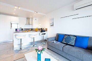 A living room with a gray couch and blue pillows