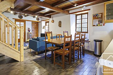 A living room with a blue couch and a dining table