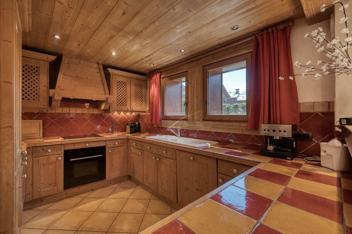 A kitchen with wooden cabinets and red tiles