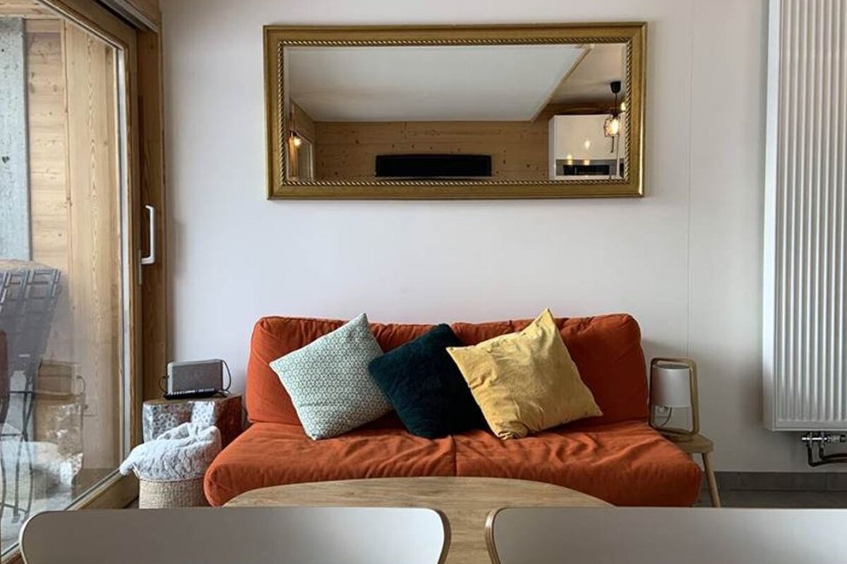 A living room with a couch and a mirror