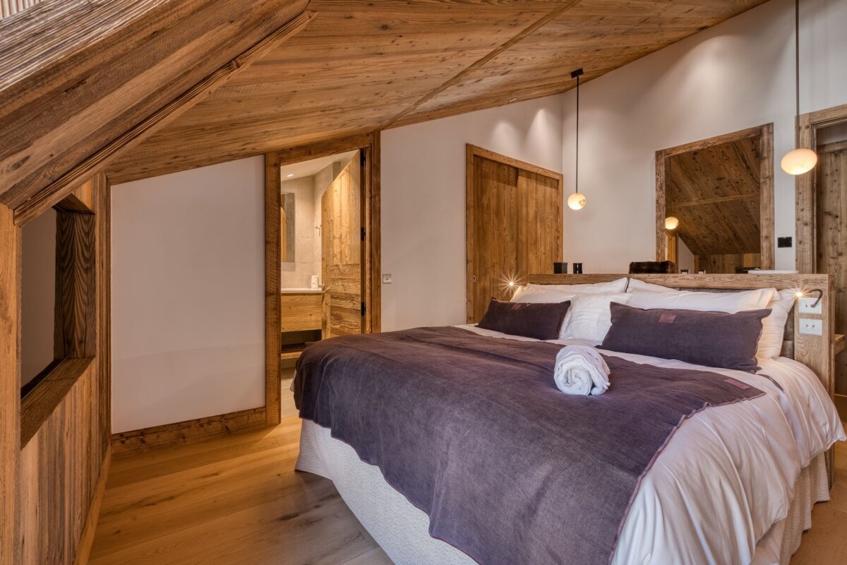 A bedroom with a large bed and a mirror
