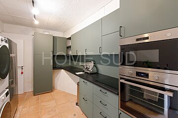 A kitchen with green cabinets and stainless steel appliances and a sign that says home sud