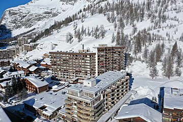 A large building with a lot of windows is covered in snow