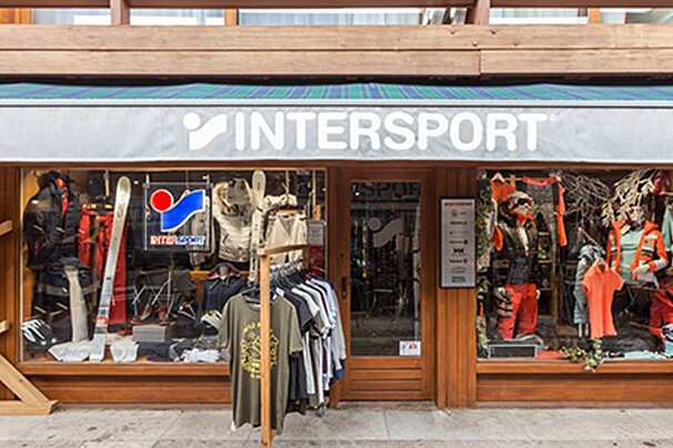 A store front for intersport with clothes hanging in front of it