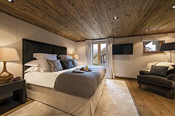 A bedroom with a large bed and a television