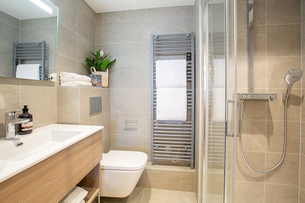 A bathroom with a toilet a sink and a towel rack