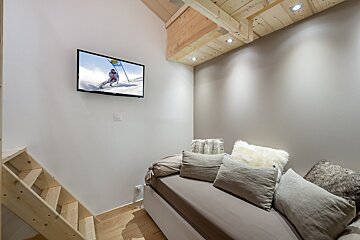 A flat screen tv shows a person skiing on a ski slope