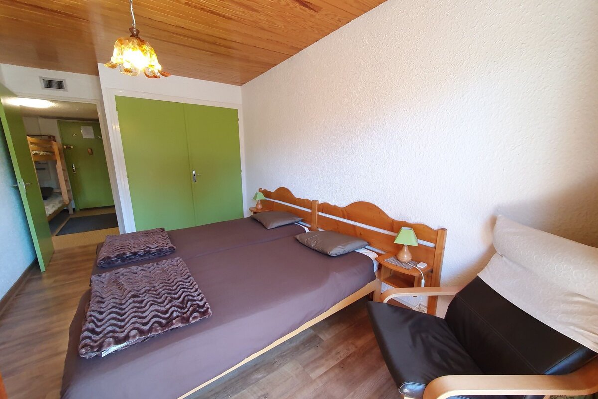 A bedroom with two beds and a chair