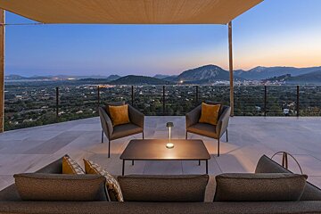 A patio with a view of a city and mountains