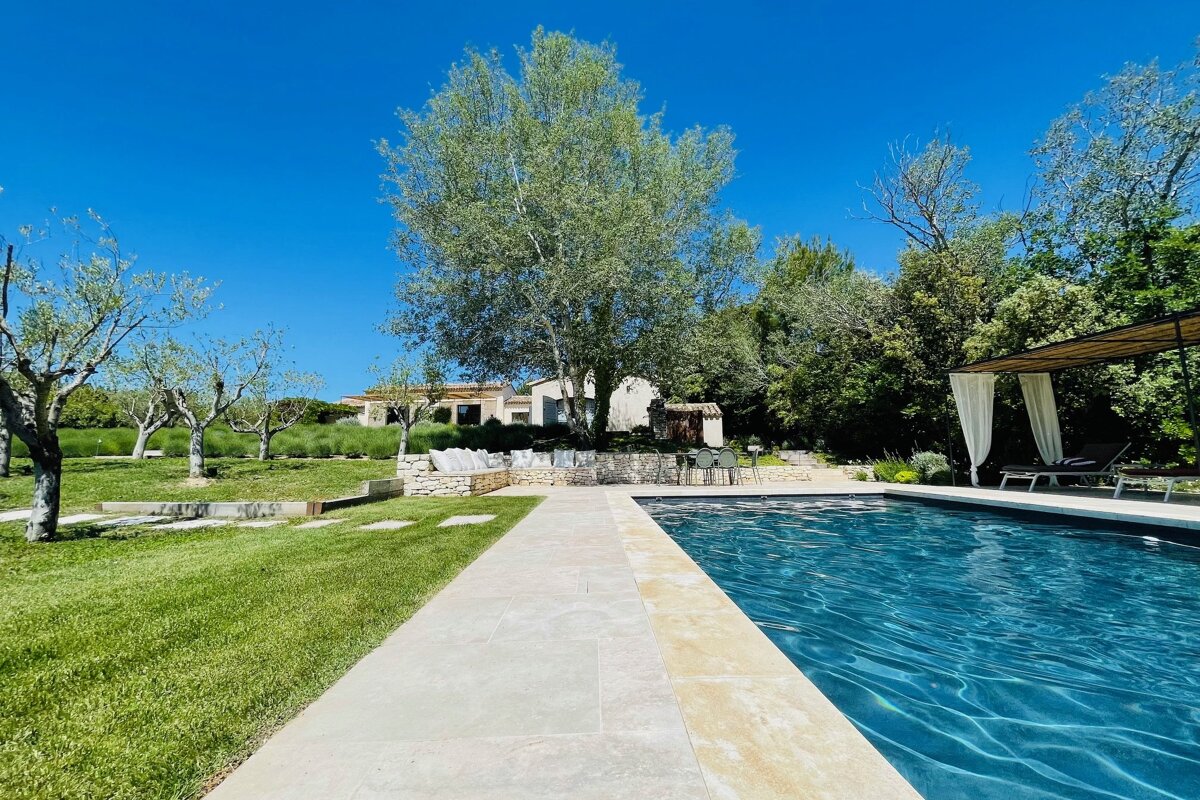 A large swimming pool surrounded by grass and trees