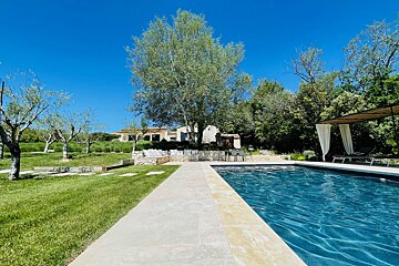 A large swimming pool surrounded by grass and trees
