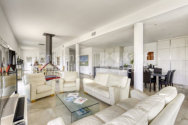 A living room with white furniture and a glass coffee table