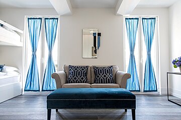 A living room with a couch and blue curtains