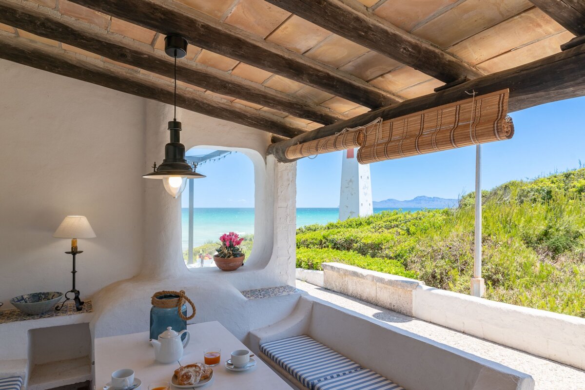 A patio with a table and a view of the ocean