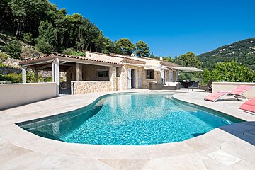 A house with a large swimming pool in front of it