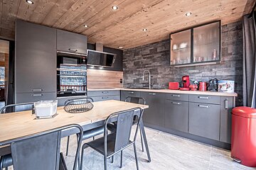A kitchen with a red trash can that says ' nespresso ' on it