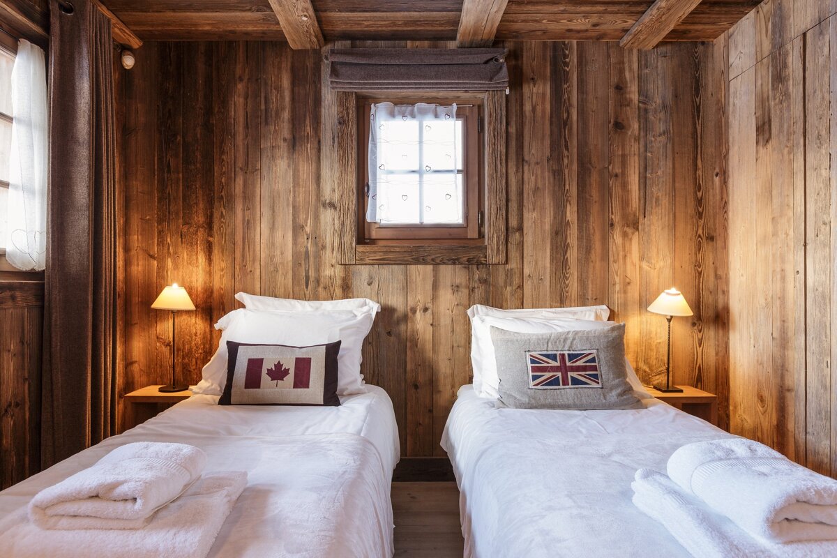 A bedroom with two beds and a pillow with the british flag on it